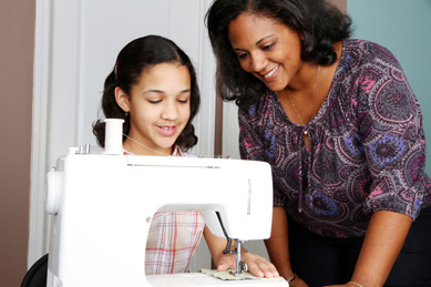Child and her mother sewing together