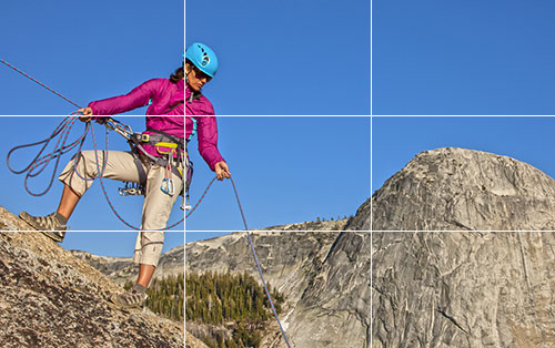 Placing the rock climber at a point of natural interest uses the rule of thirds for image composition.